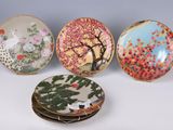 four plates with different designs on them sitting on a table