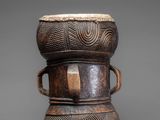 a small wooden drum with two handles on top of it