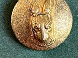 une image représentant une tête de chien sur un bouton en or
