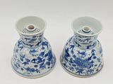 two blue and white vases sitting on a white surface