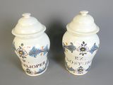 une paire de vases bleus et blancs ornés de fleurs, posés sur un fond gris