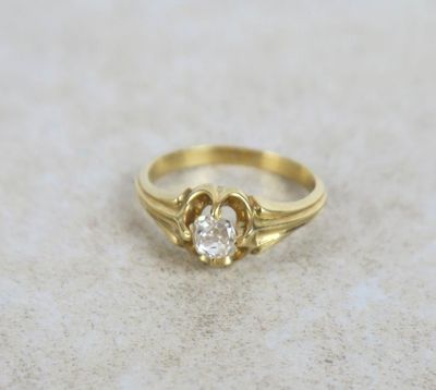 a close up of a gold ring with a diamond in the center