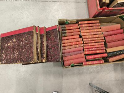 une boîte de livres posée par terre à côté d'une paire de ciseaux