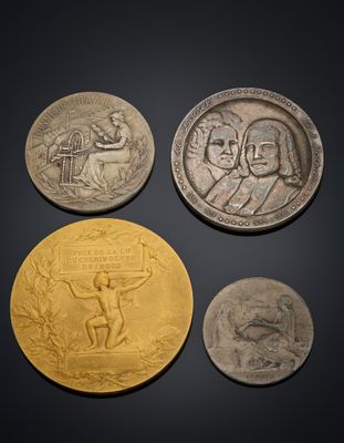 three silver and gold coins with a picture of a man holding a sword