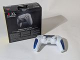 a white and blue video game controller in front of a box