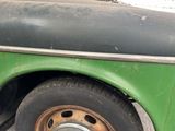 a green truck with a flat tire parked in a parking lot