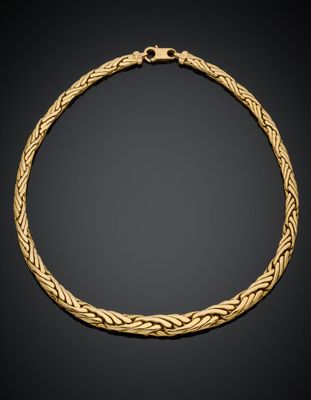 un collier en or avec un motif tressé sur fond noir