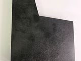 a close up of a piece of black paper on a white surface