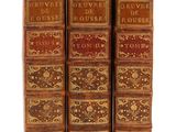 trois livres sont empilés sur une surface blanche