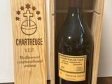 La bouteille de vin se trouve dans une caisse en bois posée sur la table.