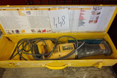 une boîte jaune posée par terre, contenant des outils