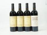 trois bouteilles de vin rouge sont alignées sur une surface blanche