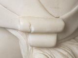 a white statue of a woman with a ring on her finger