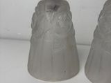 two glass bell shaped vases on a white surface