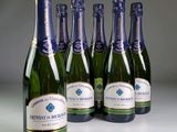 six bouteilles de vin mousseux sont alignées en rang