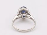 a close up of a diamond and sapphire ring on a white background