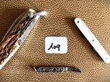 a picture of a knife and a pocket knife on a brown leather surface