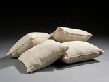 three pillows are stacked on top of each other on a gray surface