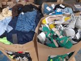 a cardboard box full of clothes and shoes on the floor