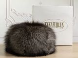 a close up of a fur ball on a table near a box