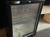 a small refrigerator that has a bottle of beer inside of it