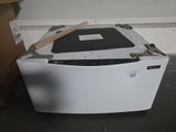 un lave-vaisselle blanc posé par terre à côté d'un carton
