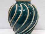 un vase bleu et blanc posé sur une surface blanche