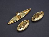 three brass plated buttons and a clasp on a black surface