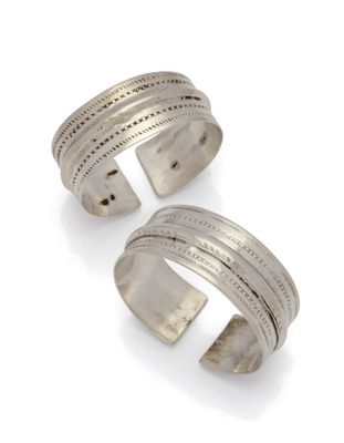 une paire de bracelets manchette en argent sur fond blanc