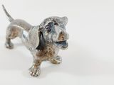 a silver dog figurine on a white surface