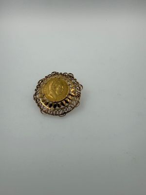 a close up of a gold coin on a white surface