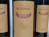 three bottles of red wine are lined up on a table