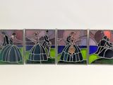 four stained glass pictures of women in dresses on a white surface