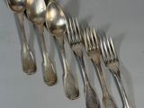 five silver spoons and six silver spoons on a table