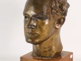 sculpture of a man ' s head on a wooden base