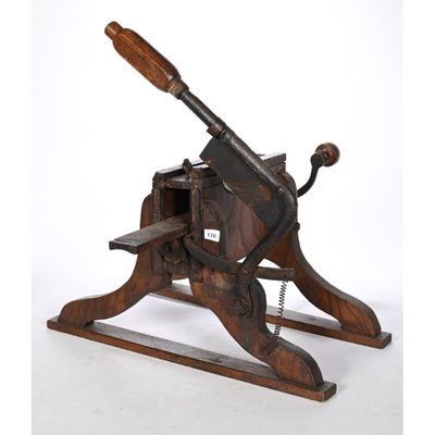 une vieille machine en bois munie d'un manche en bois, sur fond blanc