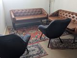 a living room with a couch, chairs and a rug