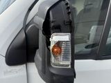 an image of a side view mirror of a white van