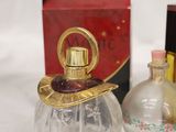a small bottle of perfume sitting next to a small box