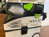 a green and black dust extracter sitting on top of a white box