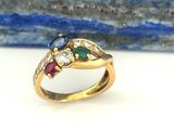 gros plan d'une bague en or avec des pierres multicolores