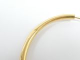 a close up of a gold colored necklace on a white surface