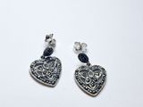 paire de boucles d'oreilles en forme de cœur en argent, ornées de cristaux bleus sur fond blanc