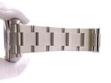 a person holding a watch in their hand on a white surface