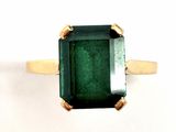 a close up of a ring with a green stone on it