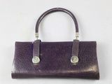 purple leather purse with two metal handles on a white surface