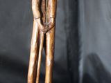 statue en bois représentant un homme tenant un enfant dans ses bras