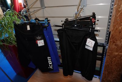 deux pantalons suspendus à un portant dans une pièce