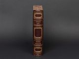 an old book sitting on top of a table next to a black background
