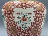 un grand vase rouge orné d'un motif floral